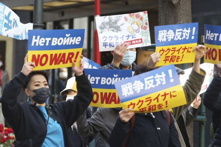 21일 일본 수도 도쿄 거리에서 마스크를 쓴 시민들이 러시아의 우크라이나 침공을 규탄 시위를 벌이고 있다. ＜사진=AP연합＞
