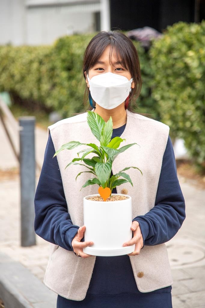 용산구청 장수연 주무관이 24일 반려식물로 제공될 스파티필름을 들고 활짝 웃고 있다.