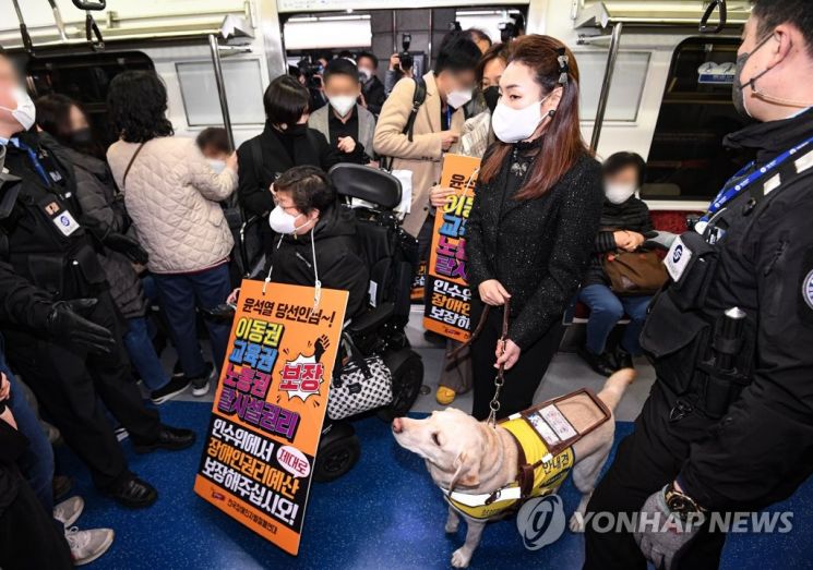 전장연 회원들과 김예지 국민의힘 의원이 28일 서울 종로구 경복궁역 3호선에서 장애인 이동권 보장·장애인 권리예산 반영을 요구하기 위해 열린 지하철 시위 '출근길 지하철 탑니다'를 위해 탑승하고 있다. / 사진=연합뉴스