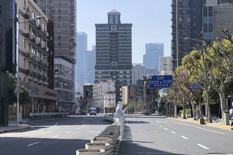 4일 중국 상하이 서쪽 징안(靜安)구의 봉쇄 지역에서 보호복을 입은 방역 요원이 텅 빈 거리 한가운데에 서 있다. 중국의 '경제수도'로 불리는 인구 2500만명의 초거대 도시 상하이는 코로나19 확산 방지를 위해 지난달 28일부터 봉쇄중이다. 사진=연합뉴스