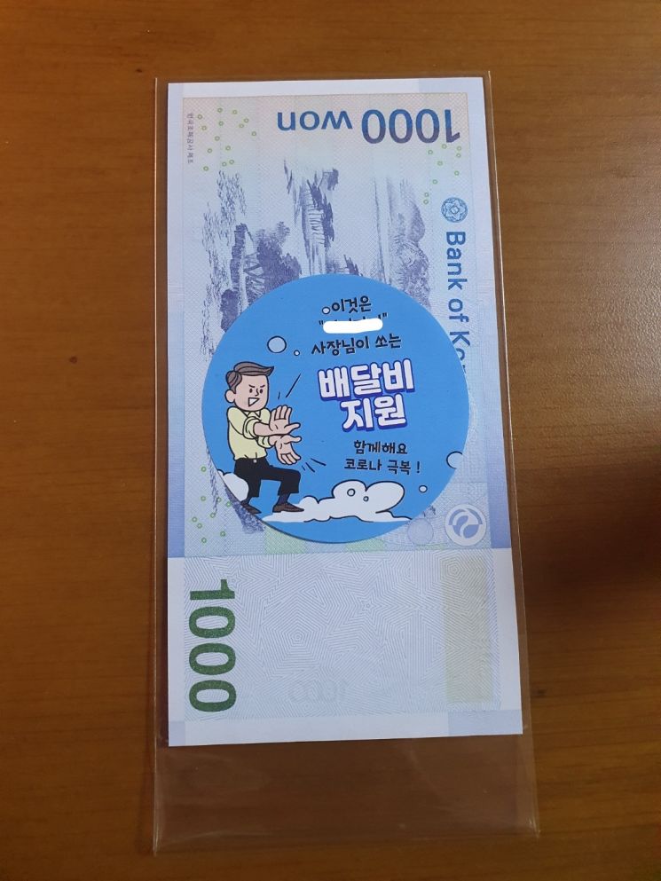 소비자 배달팁 지원을 위해 음식점주가 경품으로 제공한 1000원짜리 지폐.