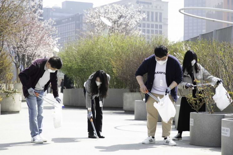 SK지오센트릭 나경수 사장(왼쪽 첫번째)과 신입사원들이 6일 서울로 주변에서 폐플라스틱 등 쓰레기를 줍는 플로깅을 하고 있다.(사진제공=SKG)