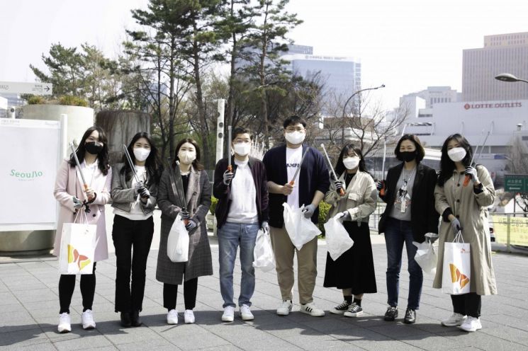 SK지오센트릭 나경수 사장(왼쪽 네번째)과 신입사원들이 서울로 주변에서 폐플라스틱 등 쓰레기를 줍는 플로깅을 한 뒤 기념사진을 촬영하고 있다.(사진제공=SKG)