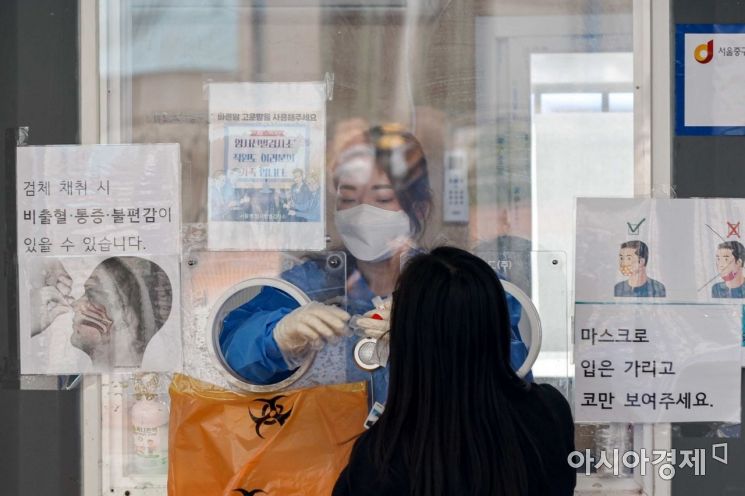 코로나19 신규 확진자가 21만755명 발생한 12일 서울역 광장에 마련된 임시선별진료소를 찾은 시민들이 검사를 받고 있다. 정부는 지난 11일부터 보건소 선별검사소와 임시선별검사소에 신속항원검사를 중단하고 PCR검사만 진행하고 있다./강진형 기자aymsdream@