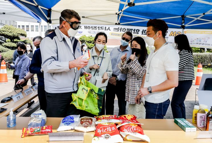 GM 한국사업장 직원들이 19일 장애체험행사에서 손으로만 물건을 구분해 구입해보는 체험을 하고 있다.＜사진제공:한국GM＞