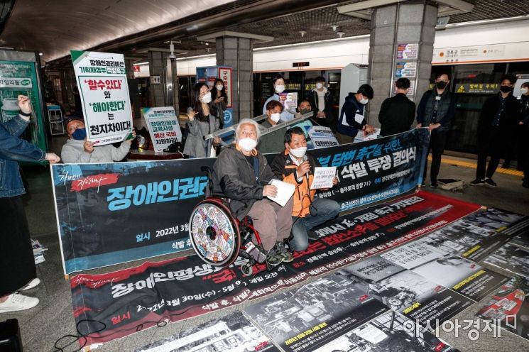 지난 4월 서울 지하철3호선 경복궁역에서 전국장애인차별철폐연대가 인수위에 예산반영 약속 이행을 촉구하며 지하철 출근길 시위를 이어가는 가운데 한 시민이 출근길 시위 반대를 요구하는 피켓시위를 하고 있다./강진형 기자aymsdream@