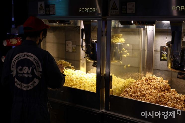 코로나19 감염병 등급이 1급에서 2급으로 내려간 25일 서울 CGV 용산아이파크몰에서 직원이 팝콘을 만들고 있다. 오늘부터 영화관, 스포츠관람장, 상점·마트·백화점 등 실내 다중이용시설과 버스·지하철·택시 등 대중교통에서 취식이 가능하다. /문호남 기자 munonam@