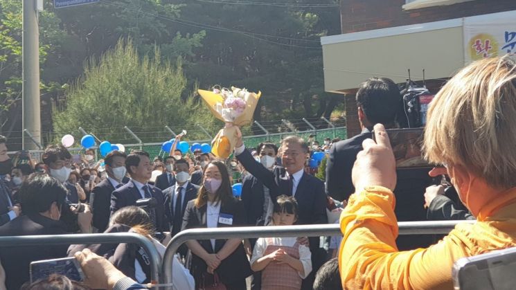 10일 오후 평산마을 사저에 입주하기 전 지지자를 향해 꽃다발을 흔드는 문재인 전 대통령.