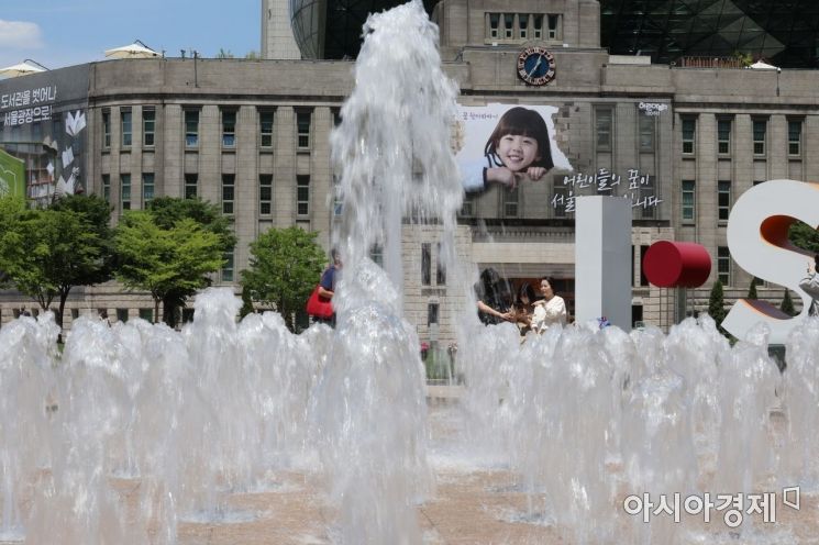 서울 낮 최고기온이 23도까지 오르는 등 초여름 날씨를 보인 15일 서울광장을 찾은 시민들이 시원하게 뿜어내는 분수를 바라보며 이른 더위를 즐기고 있다./윤동주 기자 doso7@