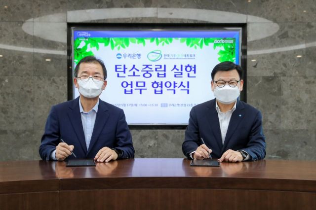 지난 17일 이원덕 우리은행장(오른쪽)과 이우균 한국기후환경네트워크  상임대표가 서울 중구 우리은행 본점에서 열린 협약식에서 기념사진을 촬영하고 있다. 사진=우리은행