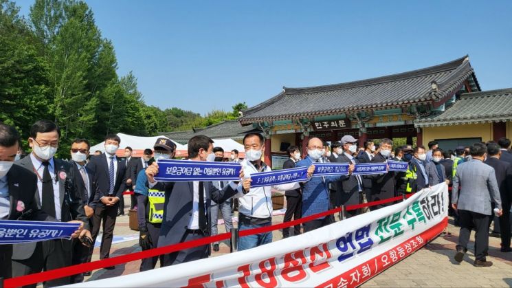 18일 42주년 5·18민주화운동 기념식이 열린 광주 북구 국립5·18민주묘지 앞에 유공자 단체 회원들이 피켓 시위를 벌이고 있다. 사진=권현지 기자