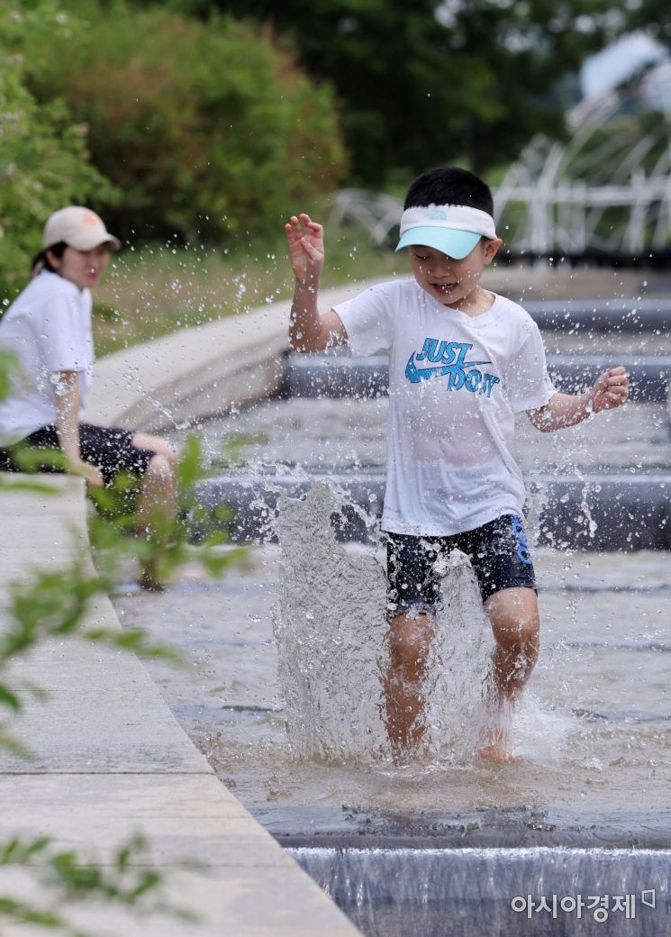초여름 날씨를 보인 20일 서울 여의도한강공원에서 부모와 나들이를 나온 아이가 물놀이를 즐기고 있다./김현민 기자 kimhyun81@