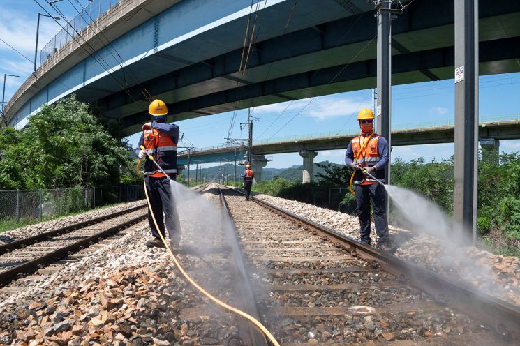철도 현장 관계자들이 뙤약볕으로 달궈진 세종 조치원역 인근 선로에 물을 뿌려 온도를 낮추고 있다. 한국철도 제공