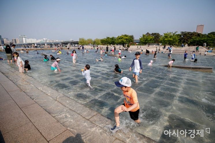 서울 한 낮 기온이 27도까지 오르며 초여름 더위가 이어지고 있는 22일 서울 여의도 한강공원 물빛광장을 찾은 시민들이 물놀이를 하며 더위를 식히고 있다./강진형 기자aymsdream@
