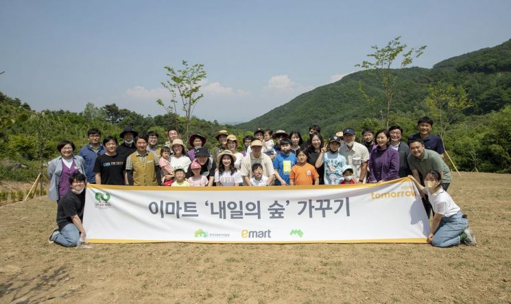 24일 경북 영주 국립산림치유원에서 이마트 임직원과 가족들이 식수 행사 후 기념사진을 찍고 있다.
