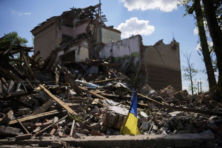 우크라이나 동부 바흐무트에서 러시아 폭격으로 파괴된 학교 잔해 사이에서 찢어진 우크라이나 국기가 흔들리고 있다 [이미지출처=AP연합뉴스]
