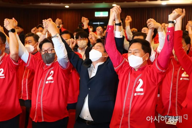 이준석 국민의힘 대표와 권성동 원내대표 등 의원들이 1일 국회 도서관 대강당에 마련된 개표상황실에서 출구조사가 발표를 보고 환호하고 있다./윤동주 기자 doso7@
