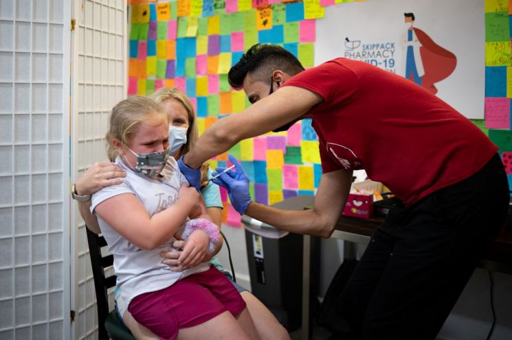 미국 펜실베이니아주 슈웬크스빌의 한 약국에서 8세 어린이가 코로나19 3차 백신(부스터샷)을 접종받고 있다. [이미지출처=연합뉴스]