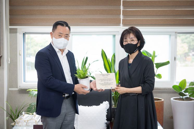 이해선 코웨이 부회장(왼쪽)이 홍은자 구로남초등학교 교장에게 '코웨이 청정학교 교실숲' 현판을 전달하고 있다.