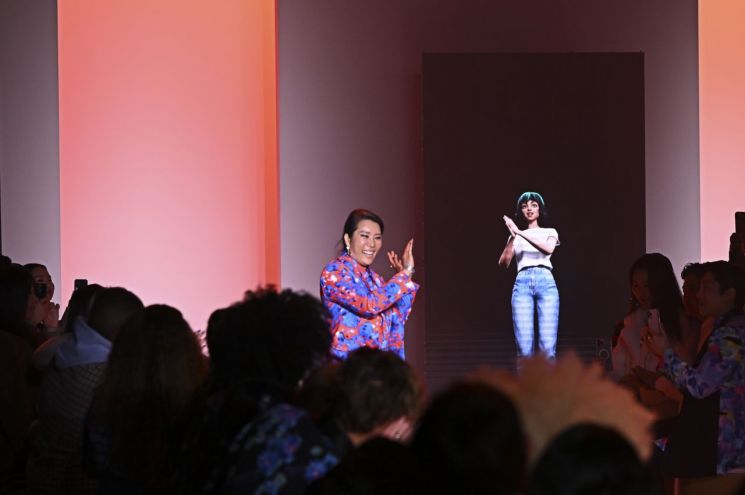 LG가 지난 2월 미국 뉴욕 패션 위크 런웨이에서 첫선을 보인 AI 아티스트 딜다가 박윤희 디자이너와 함께 인사하는 모습.(사진제공=LG)