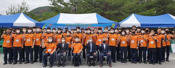 울진 덕구온천 야외주차장에 마련된 실물 화재 실험장에서 개최된 화재감식 경연대회 참가자 단체 사진.