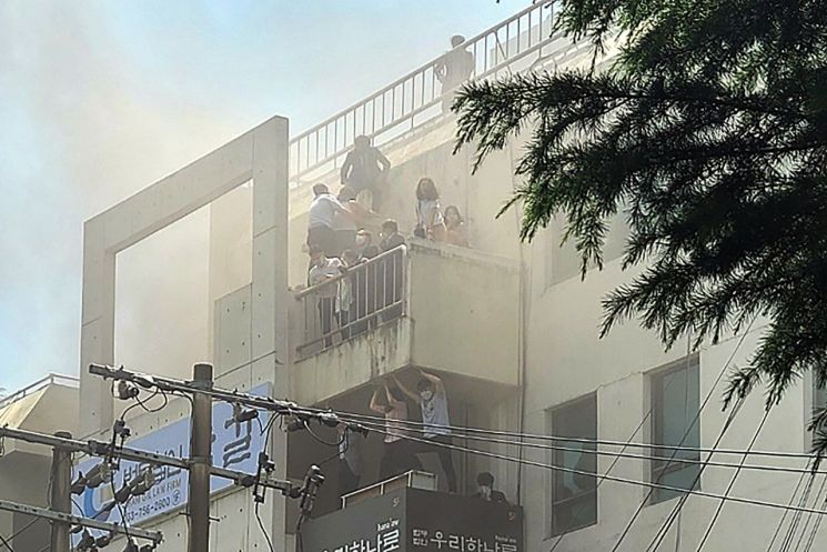 지난 9일 대구 수성구 범어동 대구지방법원 인근 변호사 사무실 빌딩에서 불이나 시민들이 옥상 부근에서 구조를 기다리고 있다./연합뉴스