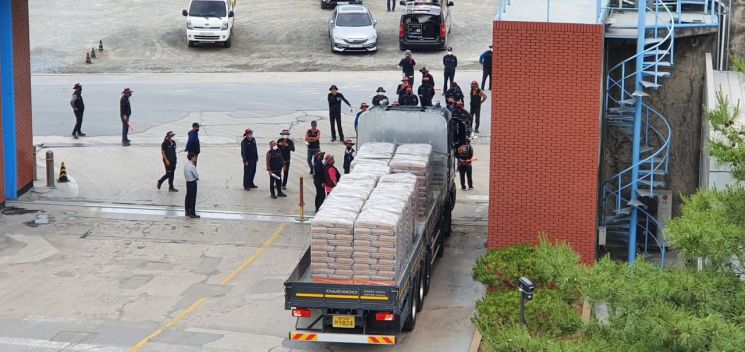 9일 오전 충북 단양의 한 시멘트 공장에서 포장시멘트 출하를 시도하다가 화물연대 조합원들의 저지를 받고 있다. 이 차량은 결국 출하를 포기하고, 공장 안으로 다시 돌아갔다. [사진제공=한국시멘트협회]