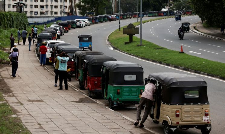 17일(현지 시각) 심각한 경제난을 겪고 있는 스리랑카 수도 콜롬보에서 삼륜차들이 장사진을 이루며 주유를 기다리고 있다. [이미지출처=연합뉴스]