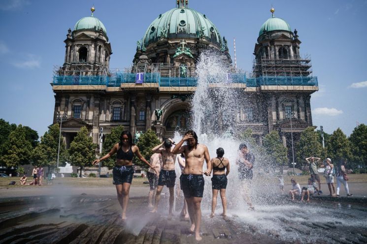 19일(현지 시각) 독일 베를린의 루스트가르텐 공원을 찾은 미국인 관광객들이 분수에서 더위를 식히고 있다. [이미지출처=연합뉴스]