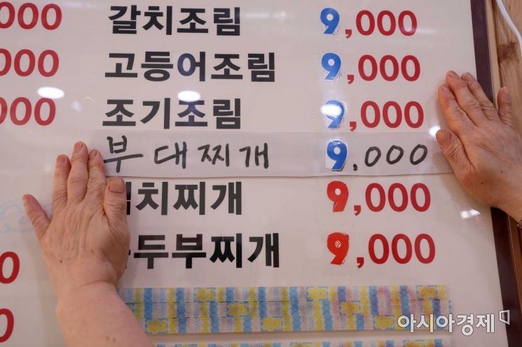 자영업자들이 물가 폭등으로 어려움을 겪고 있는 22일 서울 시내 한 식당에서 업주가 인상된 가격으로 메뉴판을 수정하고 있다. /문호남 기자 munonam@