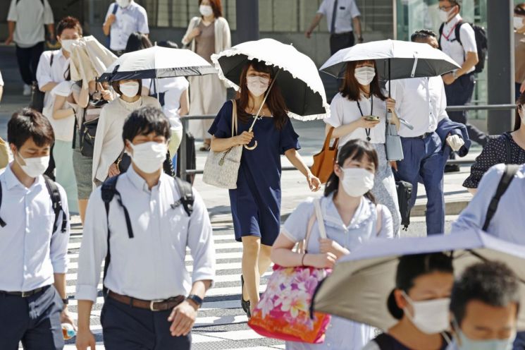 일본 도쿄 시민들이 27일 폭염 속에 교차로를 건너고 있다. 일본 정부는 때 이른 더위가 찾아오면서 전력 부족이 심각해지자 27~28일 이틀 연속 전력수급 주의보를 발령했다.     [사진 제공= AP연합뉴스]