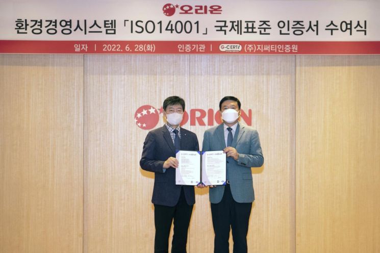 (왼쪽부터)최인권 지써티인증원 대표와 이승준 오리온 대표가 ISO 14001 인증서 수여식에서 기념촬영을 하고 있다.
