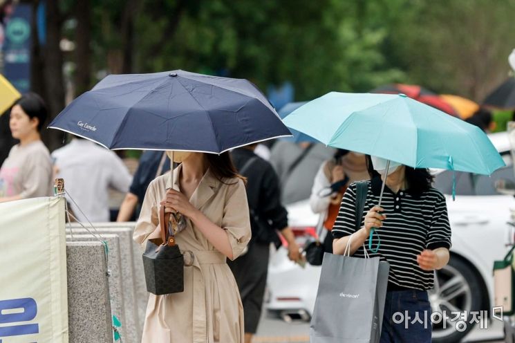 장마가 이어지고 있는 29일 서울 중구 시청역 인근에서 직장인들이 우산을 들고 출근길에 오르고 있다./강진형 기자aymsdream@