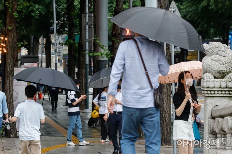 장마가 이어지고 있는 29일 서울 종로구 청계천 인근에서 시민들이 우산을 들고 이동하고 있다./강진형 기자aymsdream@