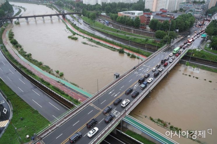중부지방을 중심으로 강한 비가 내린 30일 서울 중랑천 수위 상승으로 동부간선도로 전 구간 교통이 통제되고 있다. 인근 도로에 차량들이 거북이 걸음을 하고 있다. /문호남 기자 munonam@