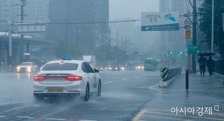 장마 전선의 영향으로 수도권에 호우경보가 발령된 30일 서울 증산교 인근에서 차량이 물보라를 일으키고 있다./강진형 기자aymsdream@