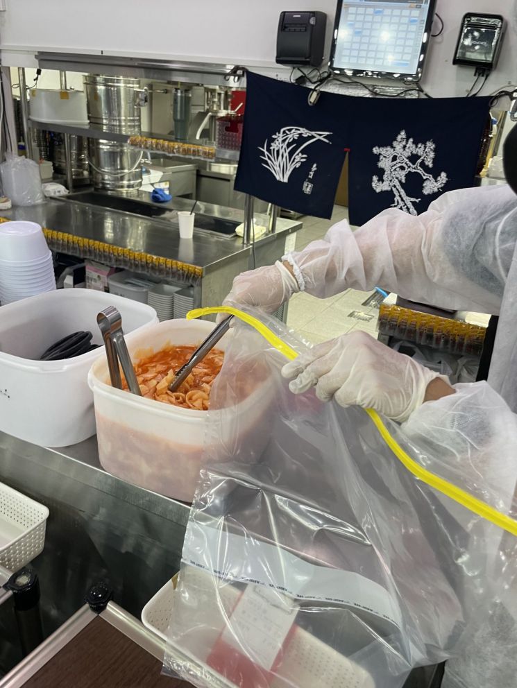 경남 김해시가 식중독 현장 대응 모의훈련에서 바이러스 검출 확인을 위해 음식물을 일부 담아내고 있다.