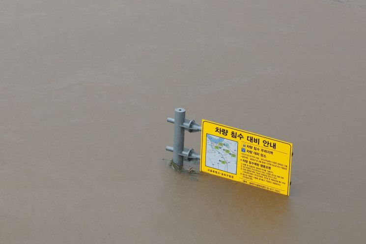 30일 오후 서울 탄천이 범람해 차량 침수 대비 안내 표지판이 물에 잠겨 있다. [이미지출처=연합뉴스]
