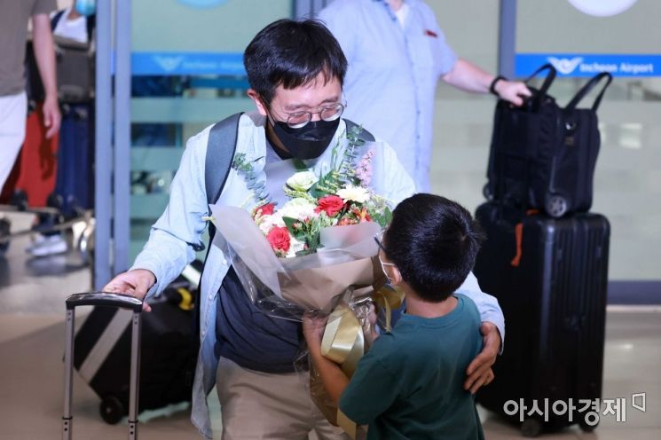 필즈상을 수상한 허준이 미국 프린스턴대 교수 겸 한국 고등과학원 수학부 석학교수가 8일 인천국제공항 제1여객터미널에서 아들에게 꽃다발을 받고 있다. /문호남 기자 munonam@