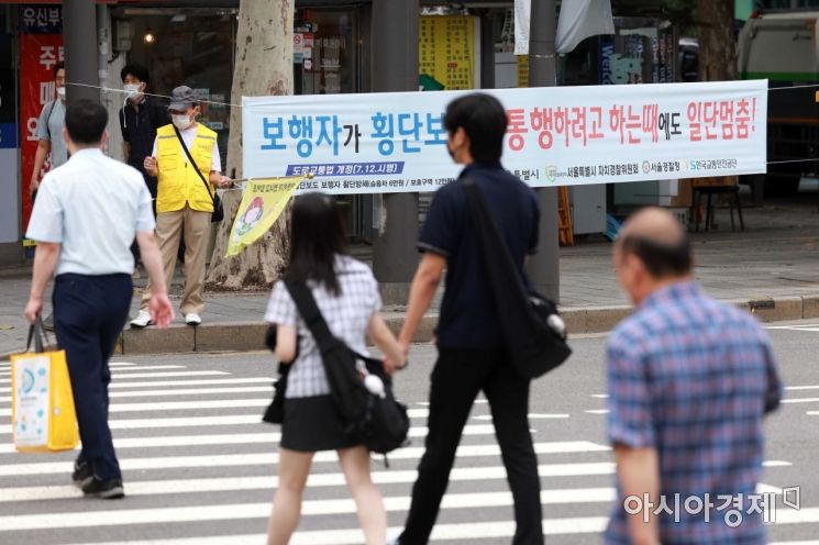 횡단보도 앞 일시정지 등 보행자 보호 의무를 강화한 도로교통법 개정안 시행 첫날인 12일 서울 이화사거리에 관련 현수막이 걸려 있다. 아시아경제