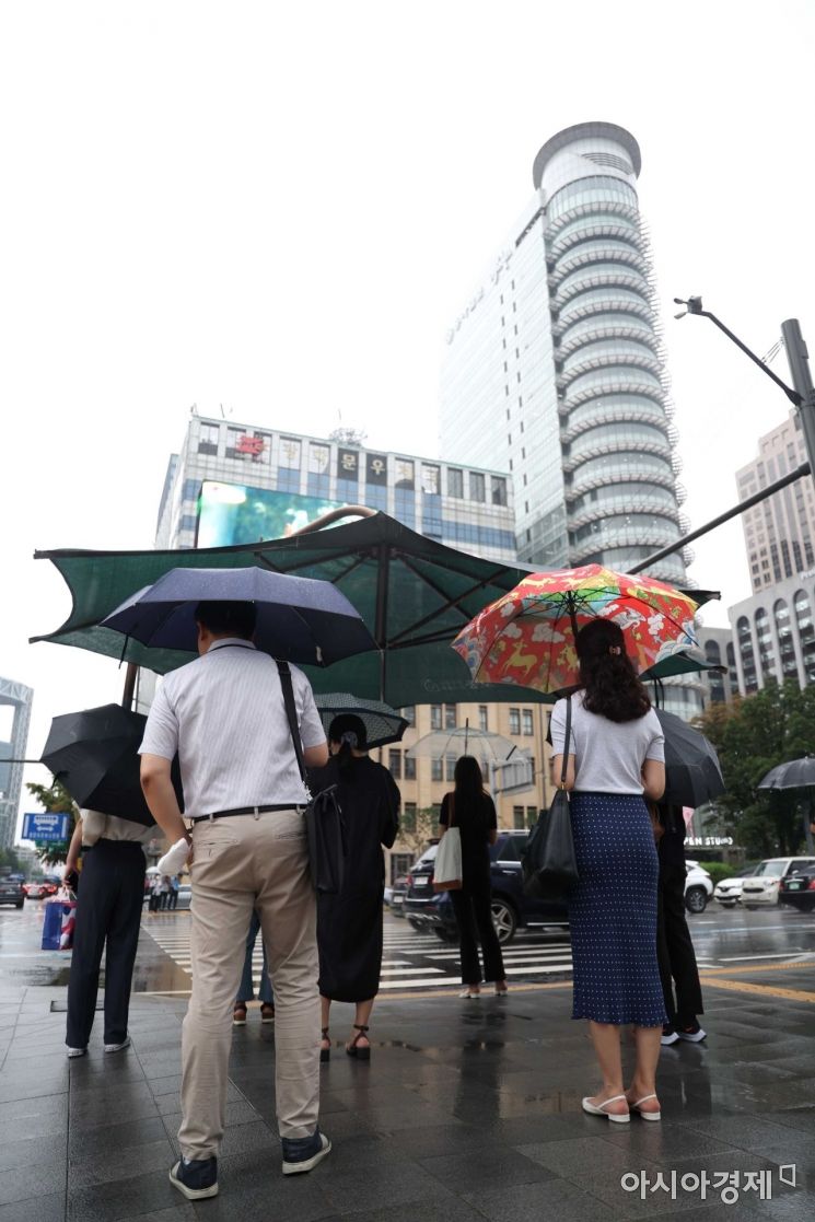 전국에 장맛비가 내린 13일 서울 광화문 사거리에서 출근길 시민들이 대형 그늘막 아래 보행 신호를 기다리고 있다. /문호남 기자 munonam@
