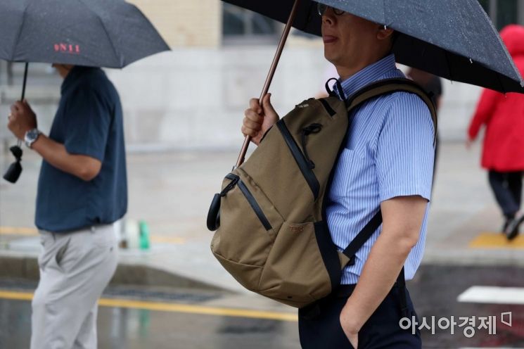 전국에 장맛비가 내린 13일 서울 광화문 사거리에서 출근길 시민이 가방이 젖지 않게 앞으로 메고 있다. /문호남 기자 munonam@