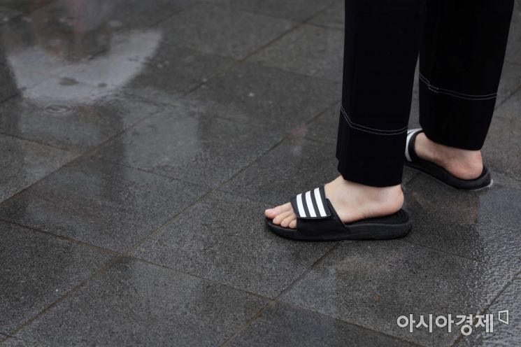 전국에 장맛비가 내린 13일 서울 광화문 사거리에서 한 시민이 슬리퍼를 신고 있다. /문호남 기자 munonam@