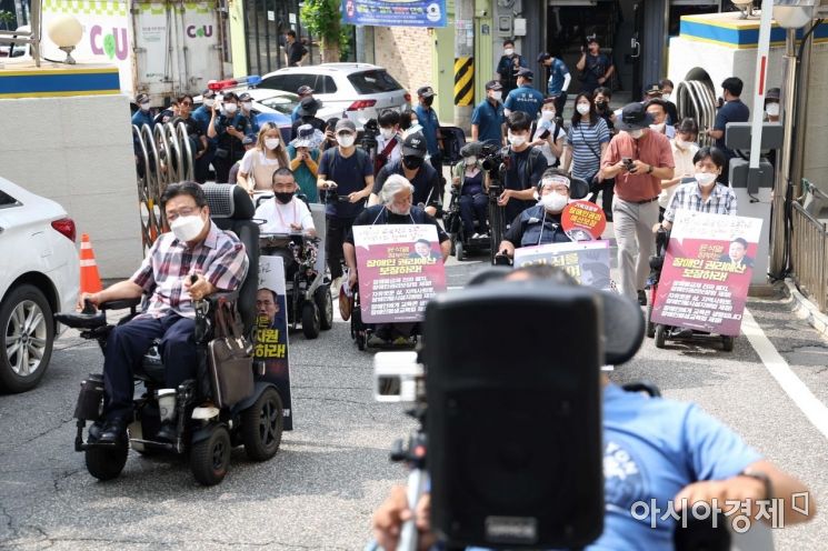 전국장애인차별철폐연대 회원들이 19일 서울 용산경찰서에 자진 출석하기 위해 언덕길을 오르고 있다. /문호남 기자 munonam@