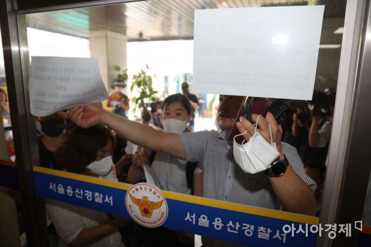 전국장애인차별철폐연대 회원들이 19일 서울 용산경찰서에 자진 출석하기 전 창문에 요구가 담긴 인쇄물을 붙이며 경찰과 마찰을 빚고 있다. /문호남 기자 munonam@