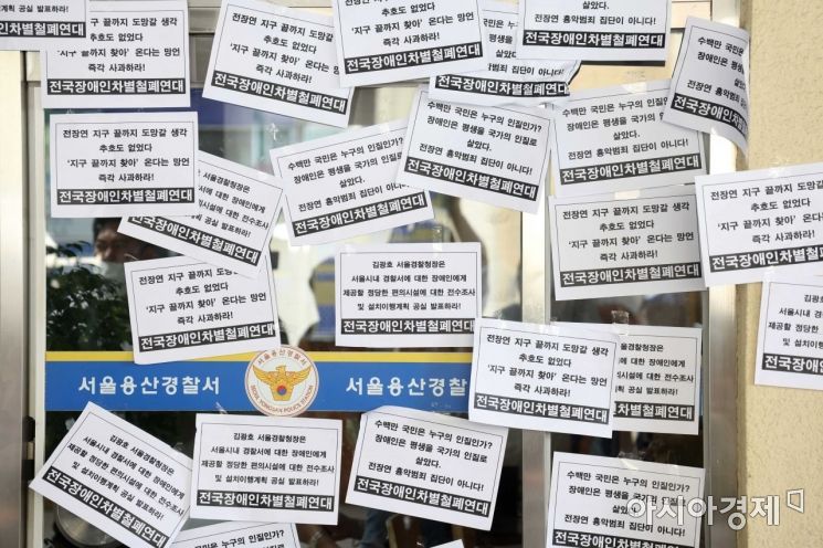 전국장애인차별철폐연대 회원들이 19일 서울 용산경찰서 창문에 장애인 편의시설 설치, 김광호 서울경찰청장 사과 등 요구가 담긴 종이를 붙였다. /문호남 기자 munonam@