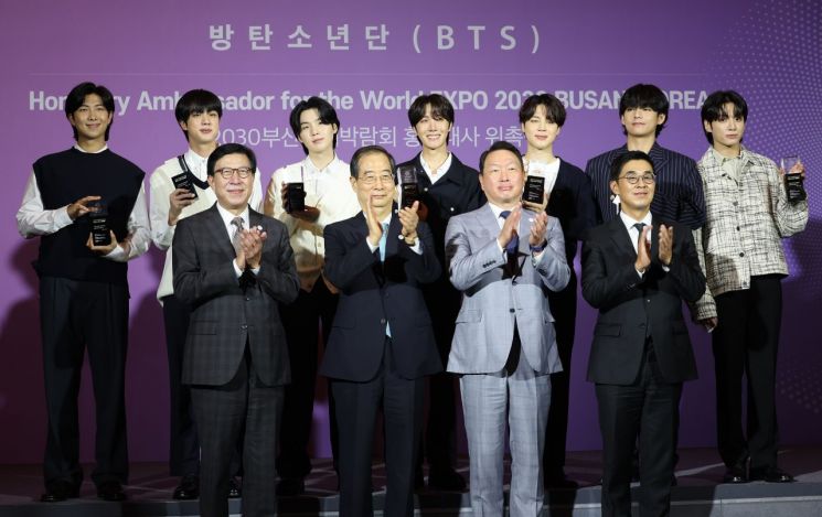 한덕수 국무총리가 19일 서울 용산구 ㈜하이브에서 방탄소년단에게 부산엑스포 홍보대사 위촉장을 수여한 뒤 참석자들과 기념촬영을 하고 있다. [이미지출처=연합뉴스]