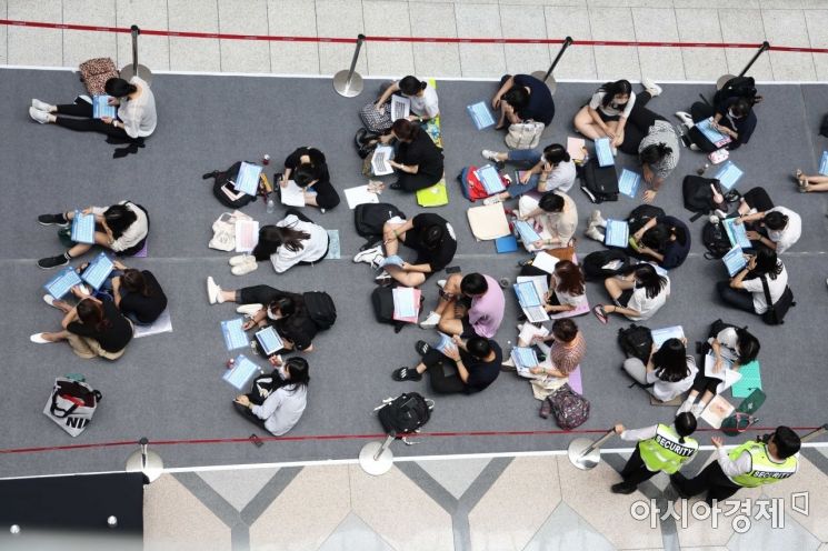 20일 서울 강남구 코엑스 A홀에서 한국대학교육협의회 주최로 열린 ‘2023학년도 수시 대학입학정보박람회’에서 학생과 학부모들이 입장을 기다리며 자료를 보고 있다. /문호남 기자 munonam@