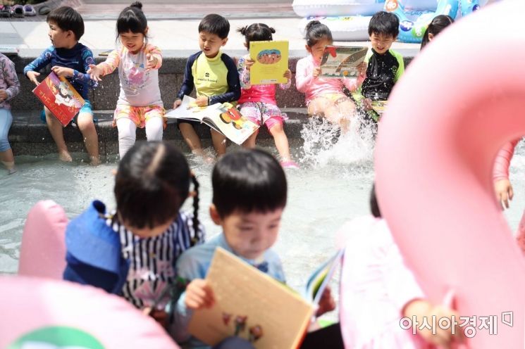 1년 중 가장 덥다는 절기 ‘대서’를 하루 앞둔 22일 서울 송파구 성내천 물놀이장을 찾은 어린이들이 물놀이를 하며 책을 읽고 있다. /문호남 기자 munonam@