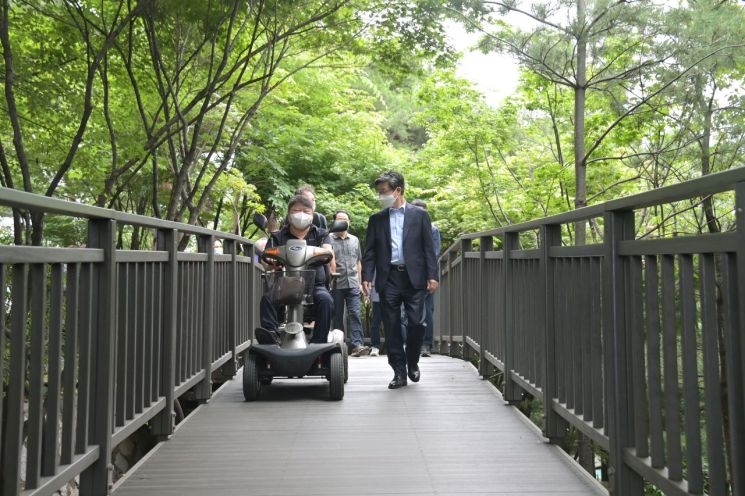 김길성 서울 중구청장(오른쪽)이 무학봉근린공원 재조성 개장식에 참석, 장애인과 함께 무학봉근린공원 무장애길을 걷고 있다.